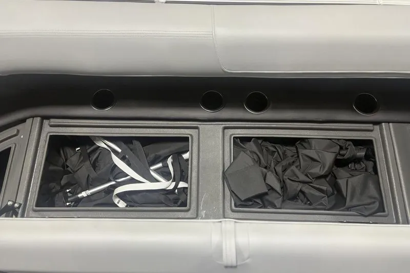 Slide: The Image of Storage compartments on a 2026 Sun Tracker Party Barge 18 DLX with black covers and accessories. - 6