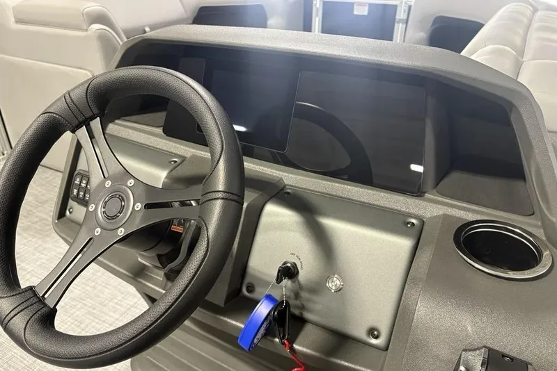 Slide: The Image of 2026 Sun Tracker PARTY BARGE® 20 DLX dashboard with steering wheel and control panel. - 18