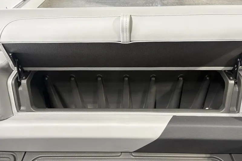 Slide: The Image of 2026 Sun Tracker PARTY BARGE® 20 DLX storage compartment with open lid, showcasing interior space. - 6