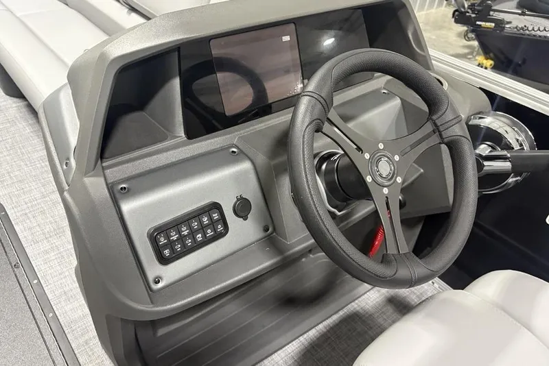 Slide: The Image of 2026 Sun Tracker Party Barge 22 XP3 dashboard with steering wheel and control panel. - 21