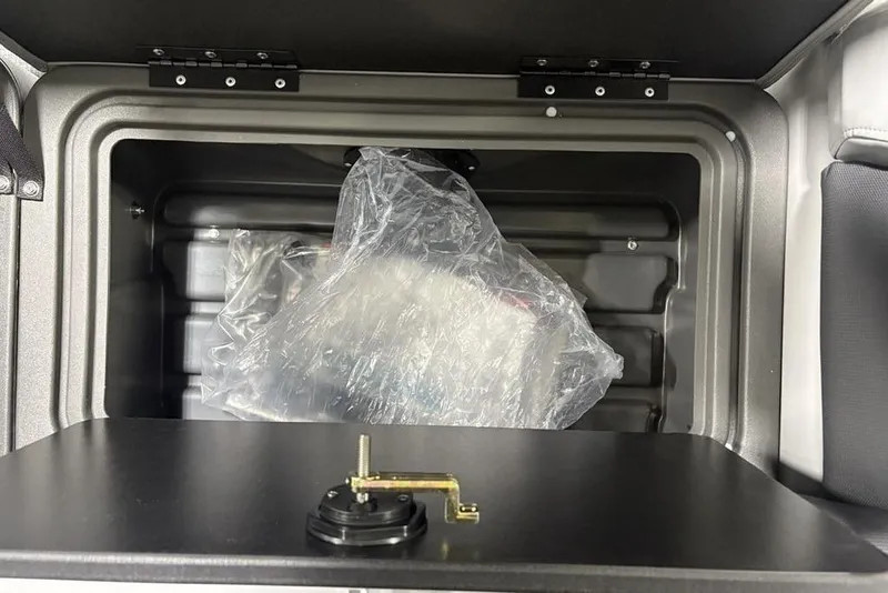 Slide: The Image of Storage compartment of 2026 Sun Tracker Party Barge 22 XP3, featuring plastic-wrapped items. - 34