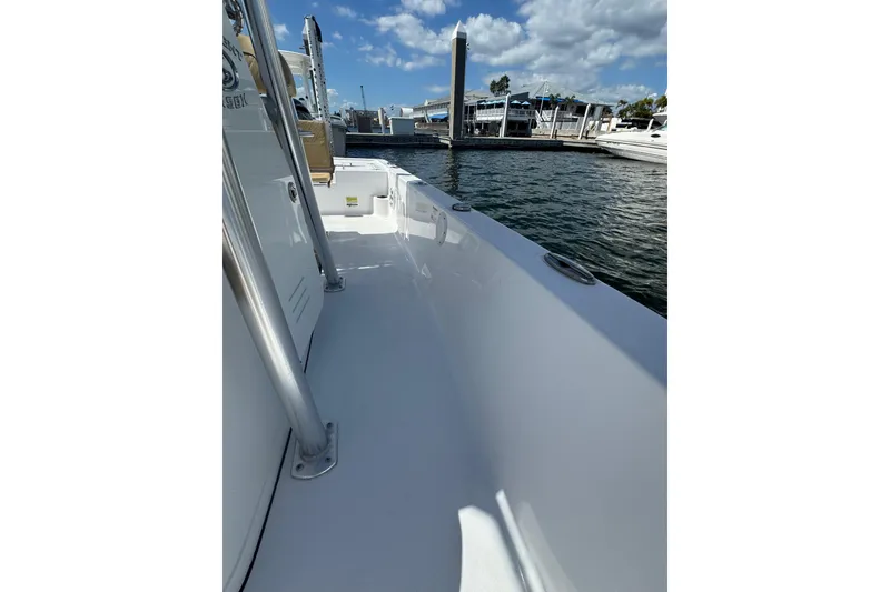 Slide: The Image of 2021 Sportsman Tournament 234 SBX Bay Boat docked at marina under blue sky. - 11