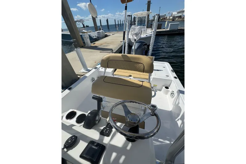 Slide: The Image of 2021 Sportsman Tournament 234 SBX Bay Boat at dock, featuring helm and seating. - 16