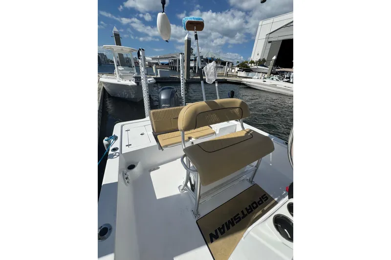 Slide: The Image of 2021 Sportsman Tournament 234 SBX Bay Boat docked, featuring tan seating and Yamaha engine. - 17