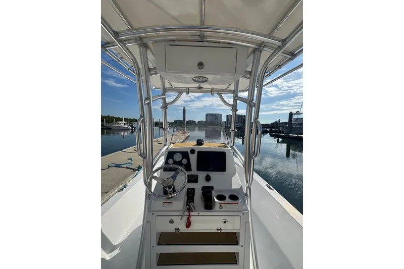 Slide: The Image of 2021 Sportsman Tournament 234 SBX Bay Boat cockpit with steering wheel and controls at marina. - 20