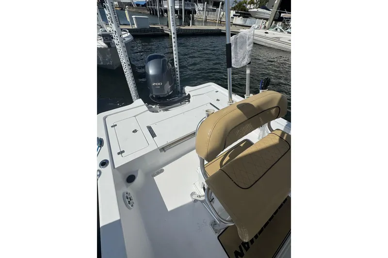 Slide: The Image of 2021 Sportsman Tournament 234 SBX Bay Boat with tan seating and powerful outboard motor. - 4