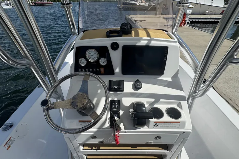 Slide: The Image of 2021 Sportsman Tournament 234 SBX Bay Boat dashboard with steering wheel and navigation controls. - 7