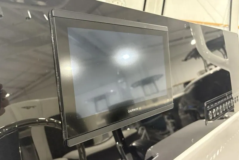 Slide: The Image of 2026 Tidewater 2210 Carolina Bay boat T-top with rod holders and speakers in a showroom. - 27