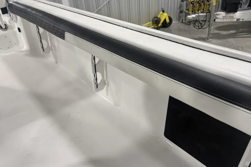Slide: The Image of 2026 Tidewater 2300 Carolina Bay boat interior with padded side rail and rod holders. - 25