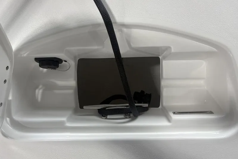 Slide: The Image of 2026 Tidewater 2300 Carolina Bay storage compartment with black strap and plug socket. - 6