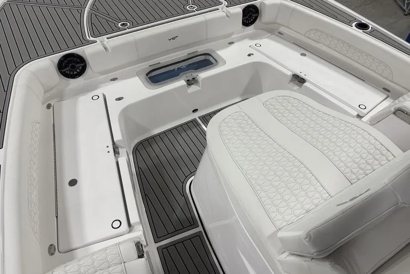 Slide: The Image of 2026 Tidewater 3100 Carolina Bay boat interior with white seating and gray flooring. - 12