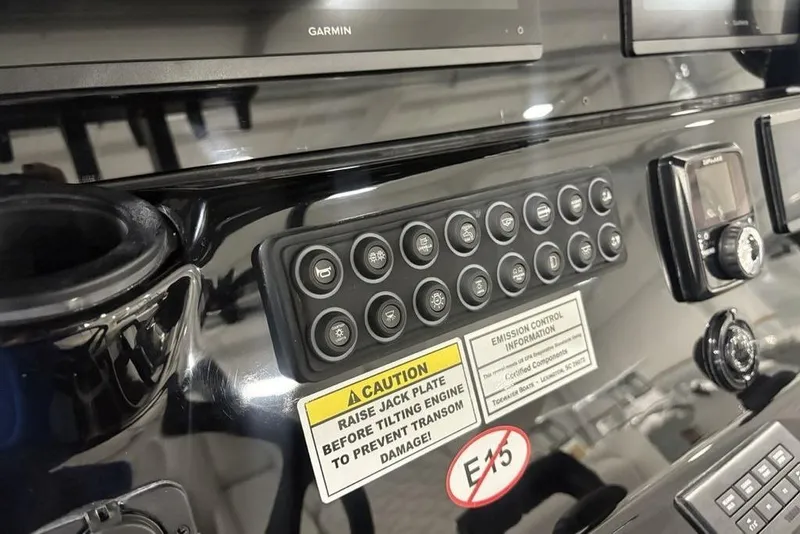 Slide: The Image of Control panel of 2026 Tidewater 3100 Carolina Bay boat with various buttons and warning labels. - 22