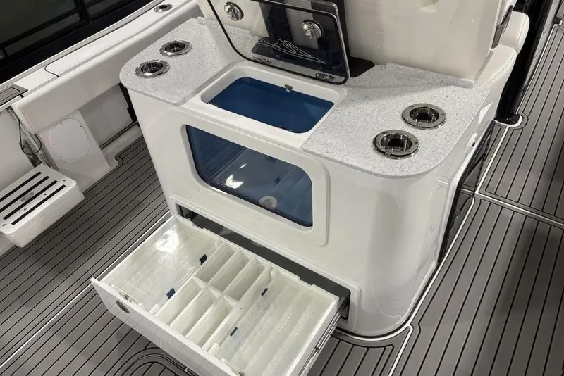 Slide: The Image of 2026 Tidewater 3100 Carolina Bay boat interior with storage compartments and cup holders. - 32