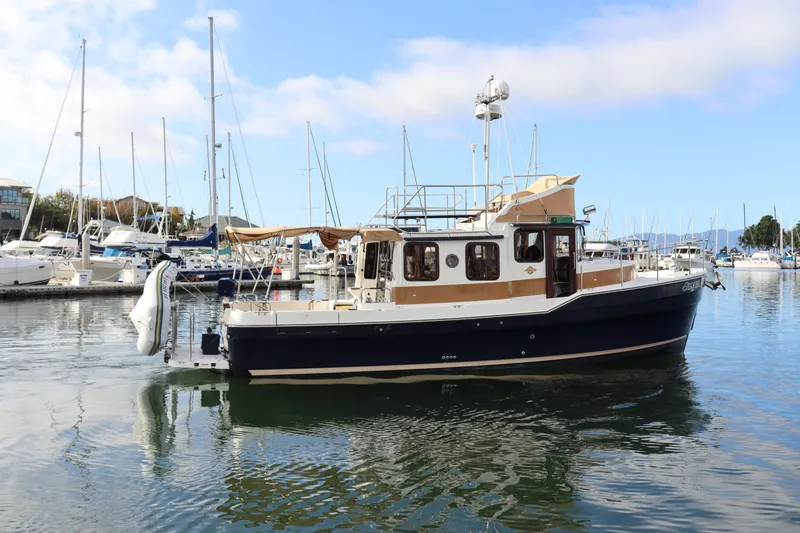 The Image of 2015 Ranger Tugs R-31 CB boat docked in a marina with sailboats. - 0