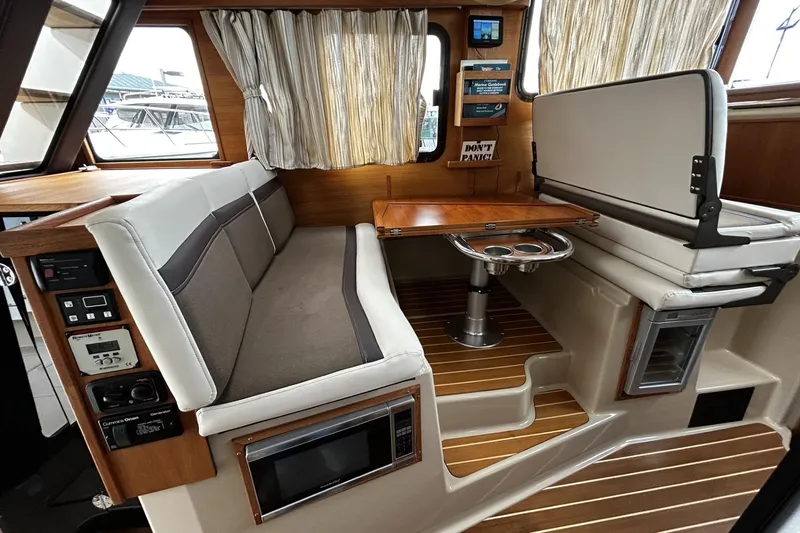 Slide: The Image of 2015 Ranger Tugs R-31 CB interior with seating, table, and control panel. - 12