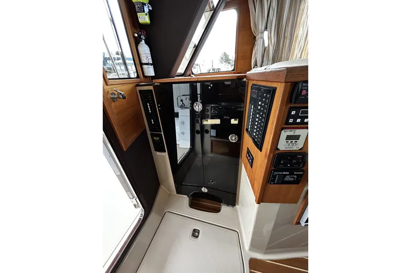 Slide: The Image of Interior view of 2015 Ranger Tugs R-31 CB, showcasing control panels and wooden finishes. - 14