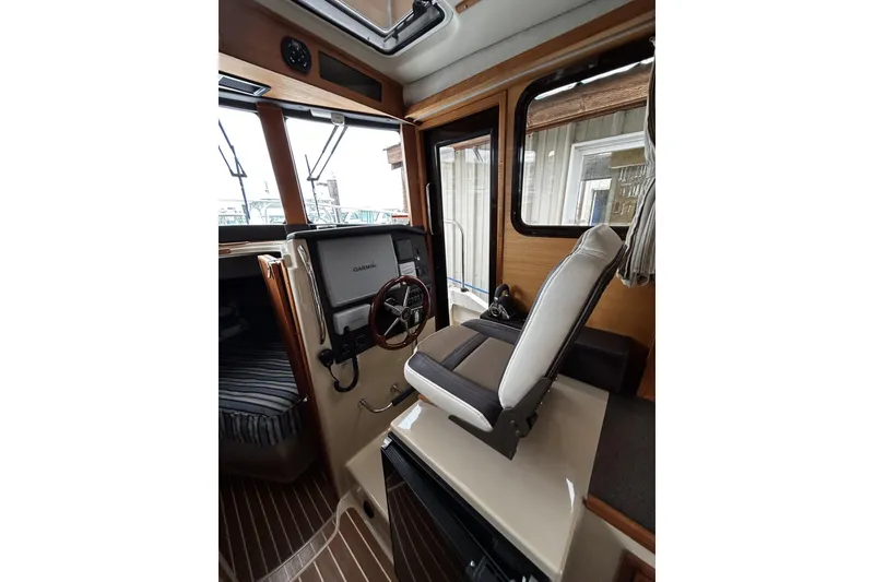 Slide: The Image of Interior of 2015 Ranger Tugs R-31 CB with helm, Garmin display, and captain's chair. - 17