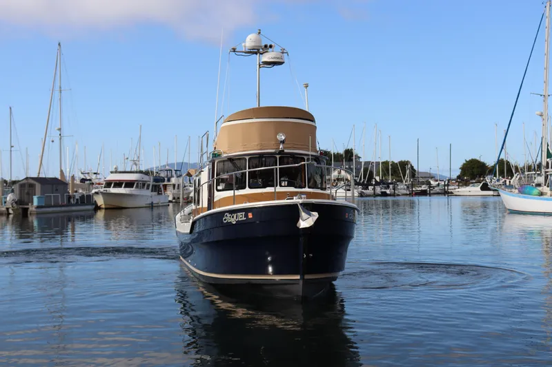 Slide: The Image of 2015 Ranger Tugs R-31 CB boat in marina, surrounded by other vessels. - 2