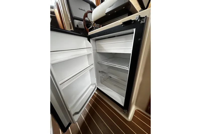 Slide: The Image of Open refrigerator inside 2015 Ranger Tugs R-31 CB boat, showcasing interior storage space. - 22
