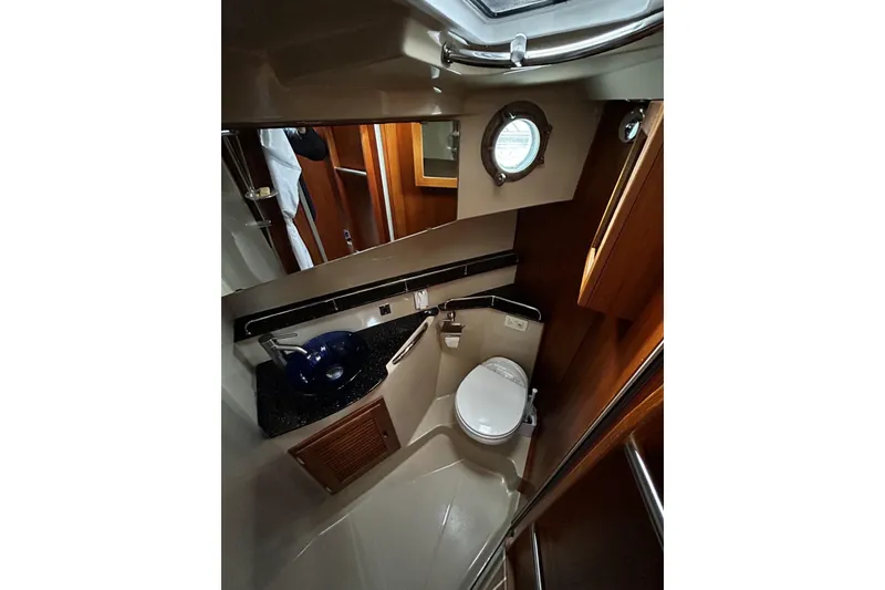Slide: The Image of 2015 Ranger Tugs R-31 CB bathroom with porthole, sink, and toilet. - 24