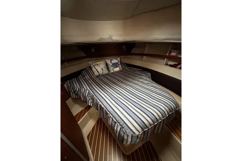 Slide: The Image of Cozy cabin interior of 2015 Ranger Tugs R-31 CB with striped bedding and nautical decor. - 25