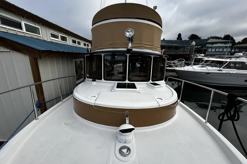 Slide: The Image of 2015 Ranger Tugs R-31 CB boat docked at marina, overcast sky. - 27