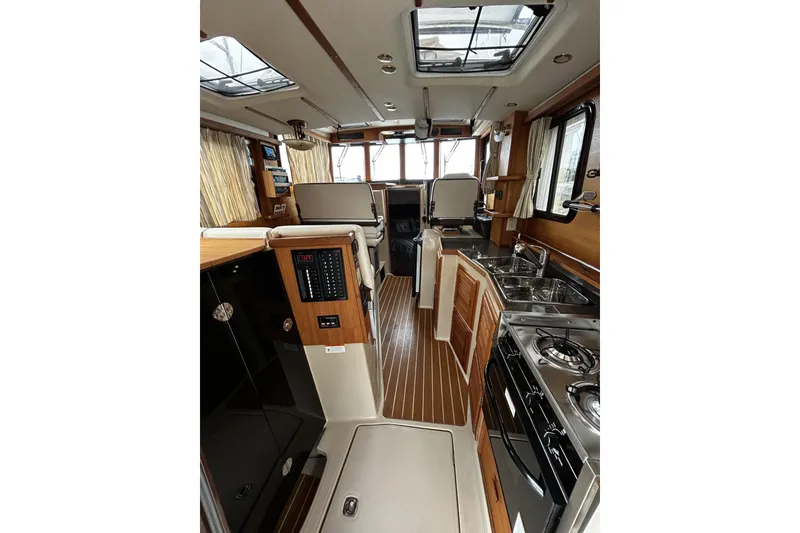 Slide: The Image of Interior of 2015 Ranger Tugs R-31 CB, featuring kitchen and seating area. - 7