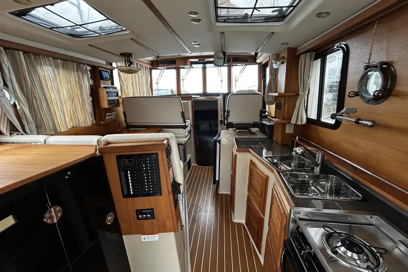 Slide: The Image of Interior of 2015 Ranger Tugs R-31 CB, featuring wood accents and modern amenities. - 8