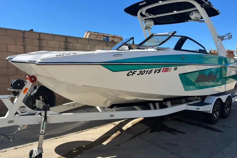 Slide: The Image of 2020 Malibu Wakesetter 23 MXZ boat on trailer, parked outdoors. - 1