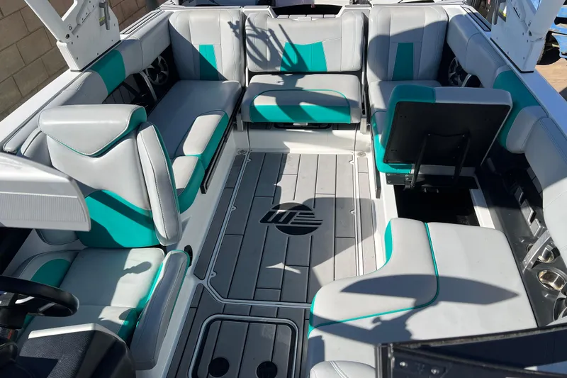 Slide: The Image of 2020 Malibu Wakesetter 23 MXZ interior with teal and gray seating, spacious layout. - 10