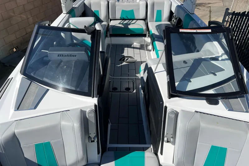 Slide: The Image of 2020 Malibu Wakesetter 23 MXZ boat interior with teal and gray seating. - 11