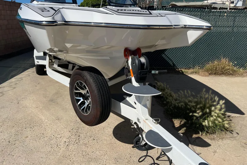 Slide: The Image of 2020 Malibu Wakesetter 23 MXZ boat on trailer, parked outdoors. - 19