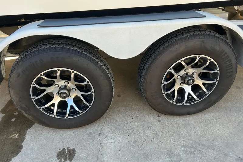 Slide: The Image of Trailer wheels of a 2020 Malibu Wakesetter 23 MXZ on concrete surface. - 22