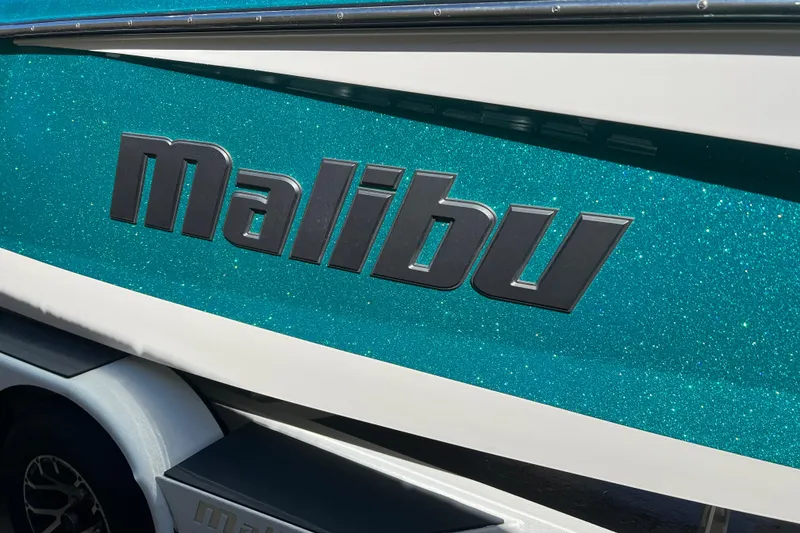 Slide: The Image of 2020 Malibu Wakesetter 23 MXZ boat with sparkling teal finish and bold logo. - 23