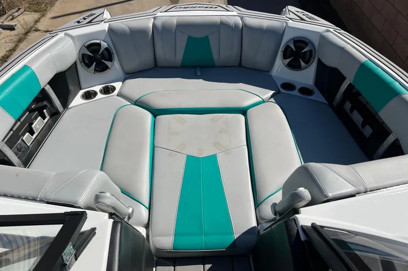 Slide: The Image of 2020 Malibu Wakesetter 23 MXZ boat interior with teal and gray seating, cup holders, and speakers. - 25