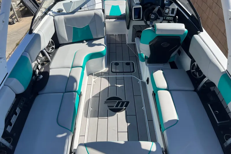 Slide: The Image of 2020 Malibu Wakesetter 23 MXZ interior with teal and gray seating, modern dashboard. - 5