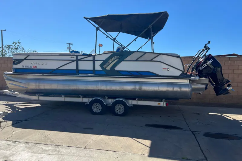 The Image of 2020 Crest Caribbean RS 250 SLRC pontoon boat on trailer with Suzuki outboard motor. - 0