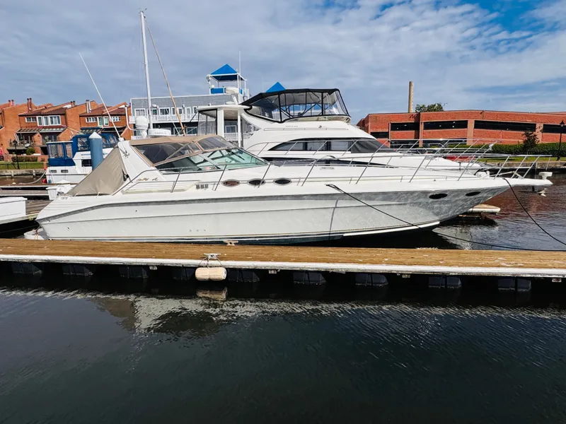 Slide: The Image of 1995 Sea Ray 400 Express Cruiser docked at marina, clear sky background. - 1