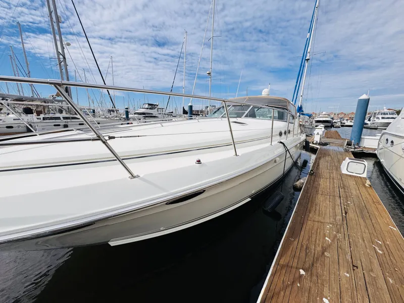 Slide: The Image of 1995 Sea Ray 400 Express Cruiser docked at marina under blue sky. - 2