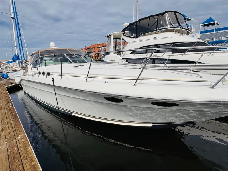 Slide: The Image of 1995 Sea Ray 400 Express Cruiser docked at marina, featuring sleek white design. - 3