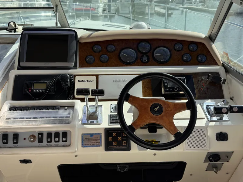 Slide: The Image of 1995 Sea Ray 400 Express Cruiser helm with steering wheel and navigation controls. - 4