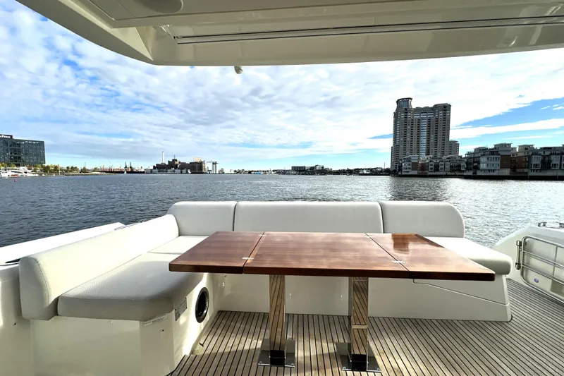 Slide: The Image of Luxury yacht Prestige 590, 2023 model, with elegant deck seating and waterfront view. - 11