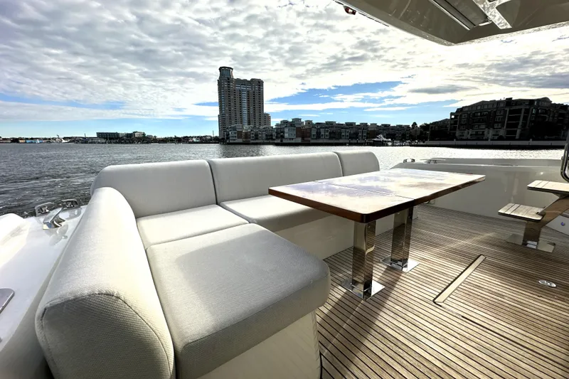 Slide: The Image of Luxurious 2023 Prestige 590 yacht deck with elegant seating and scenic waterfront view. - 12