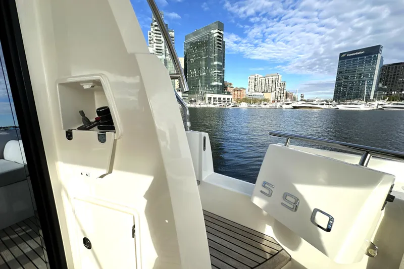 Slide: The Image of 2023 Prestige 590 yacht docked in urban marina with city skyline. - 15