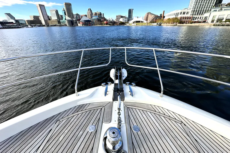 Slide: The Image of Bow view of 2023 Prestige 590 yacht approaching city skyline over calm water. - 18