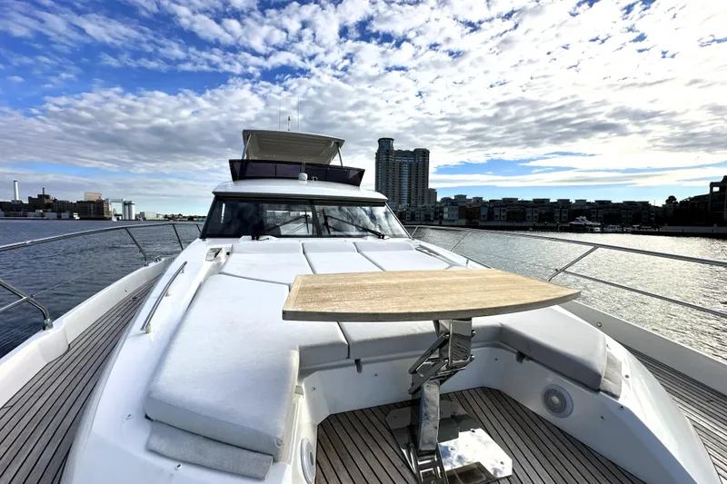 Slide: The Image of 2023 Prestige 590 yacht on water, featuring spacious deck and modern design. - 19