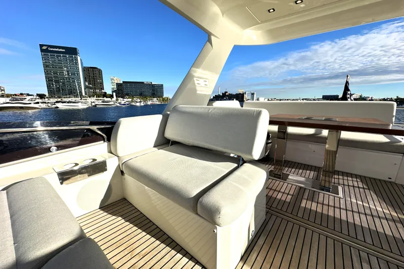 Slide: The Image of Luxurious 2023 Prestige 590 yacht deck with modern seating and scenic waterfront view. - 27
