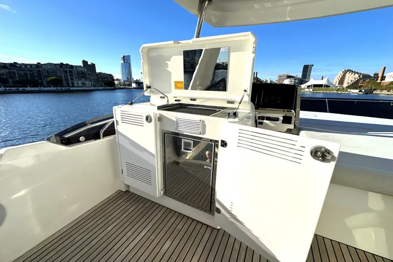 Slide: The Image of Prestige 590 yacht outdoor kitchen area with cityscape view, 2023 model. - 29