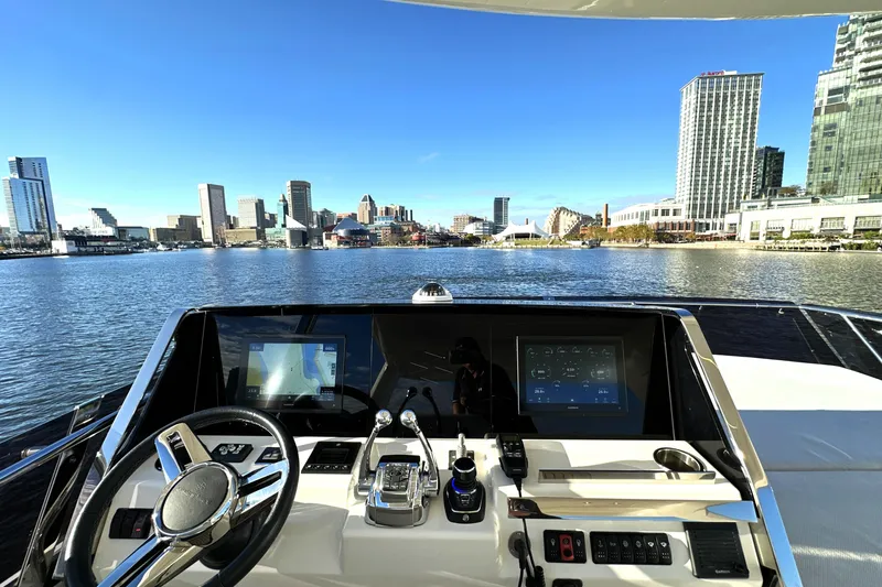 Slide: The Image of Helm of 2023 Prestige 590 yacht overlooking city skyline and waterfront. - 33
