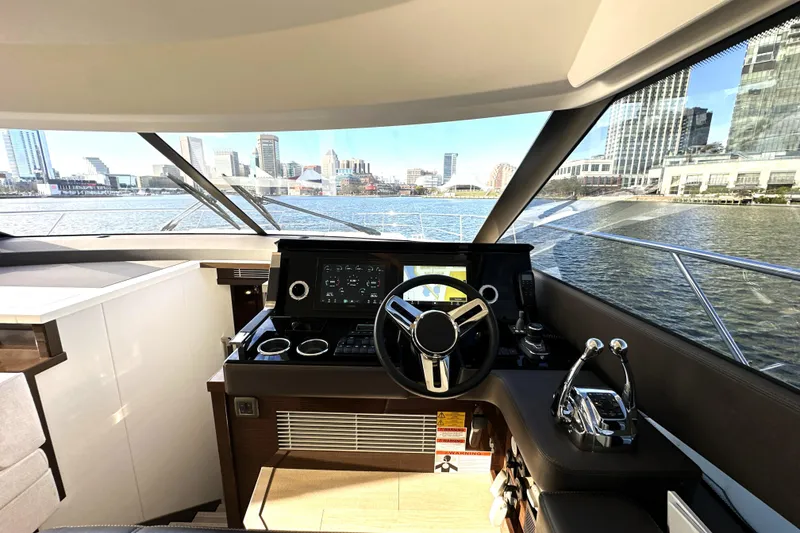 Slide: The Image of Luxurious 2023 Prestige 590 yacht helm with city skyline view through large windows. - 52